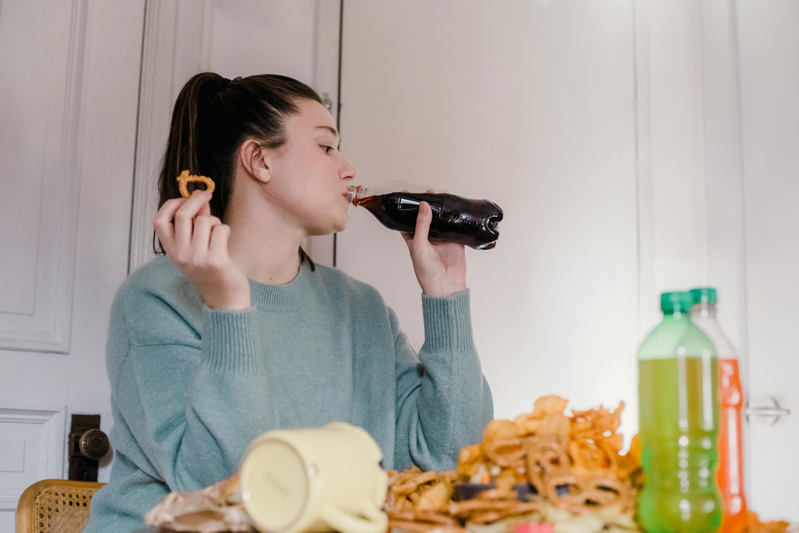 Woman drinking soft drink and eating junk food linked to belly fat gain
